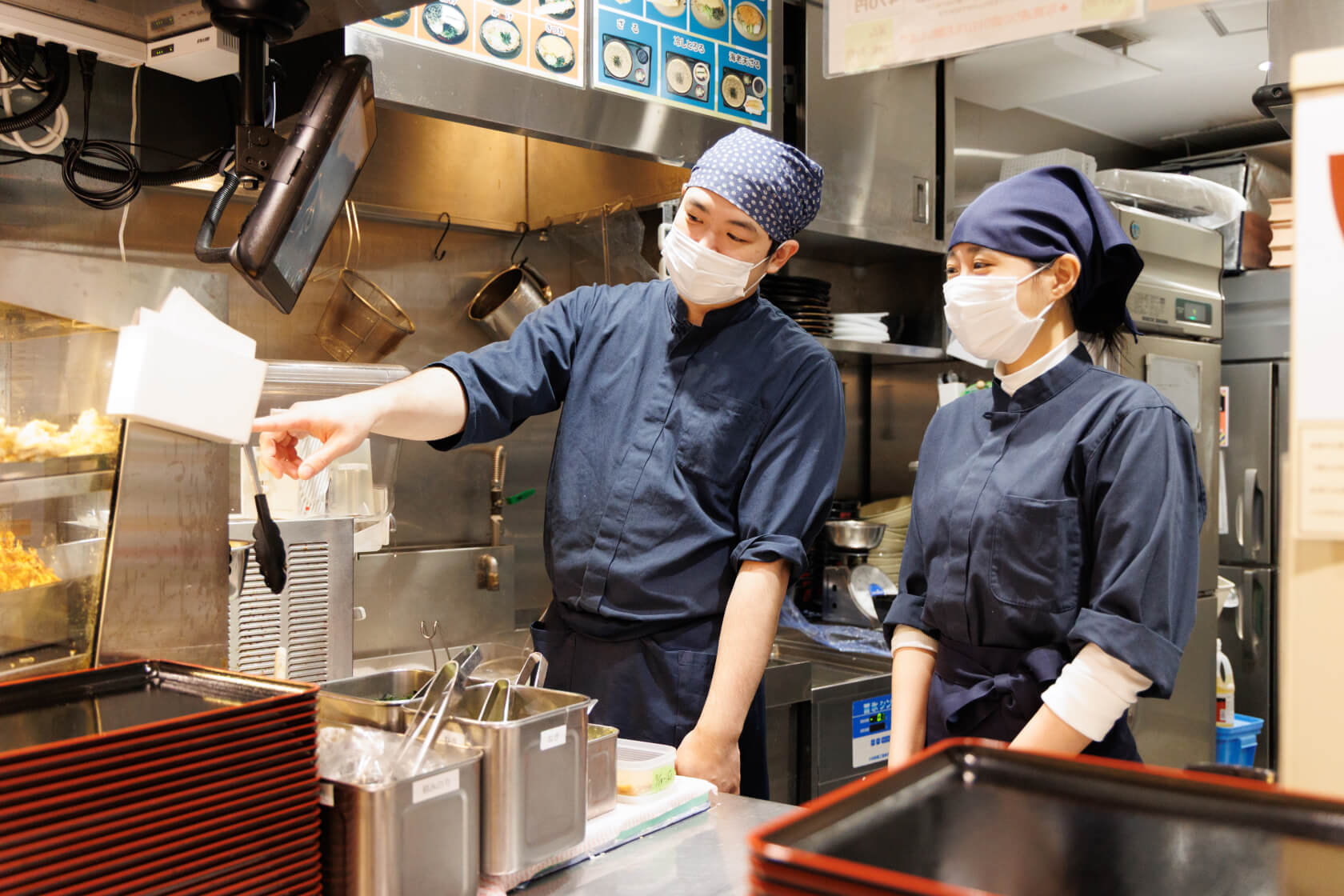 店長が社員に丁寧に教えている様子。