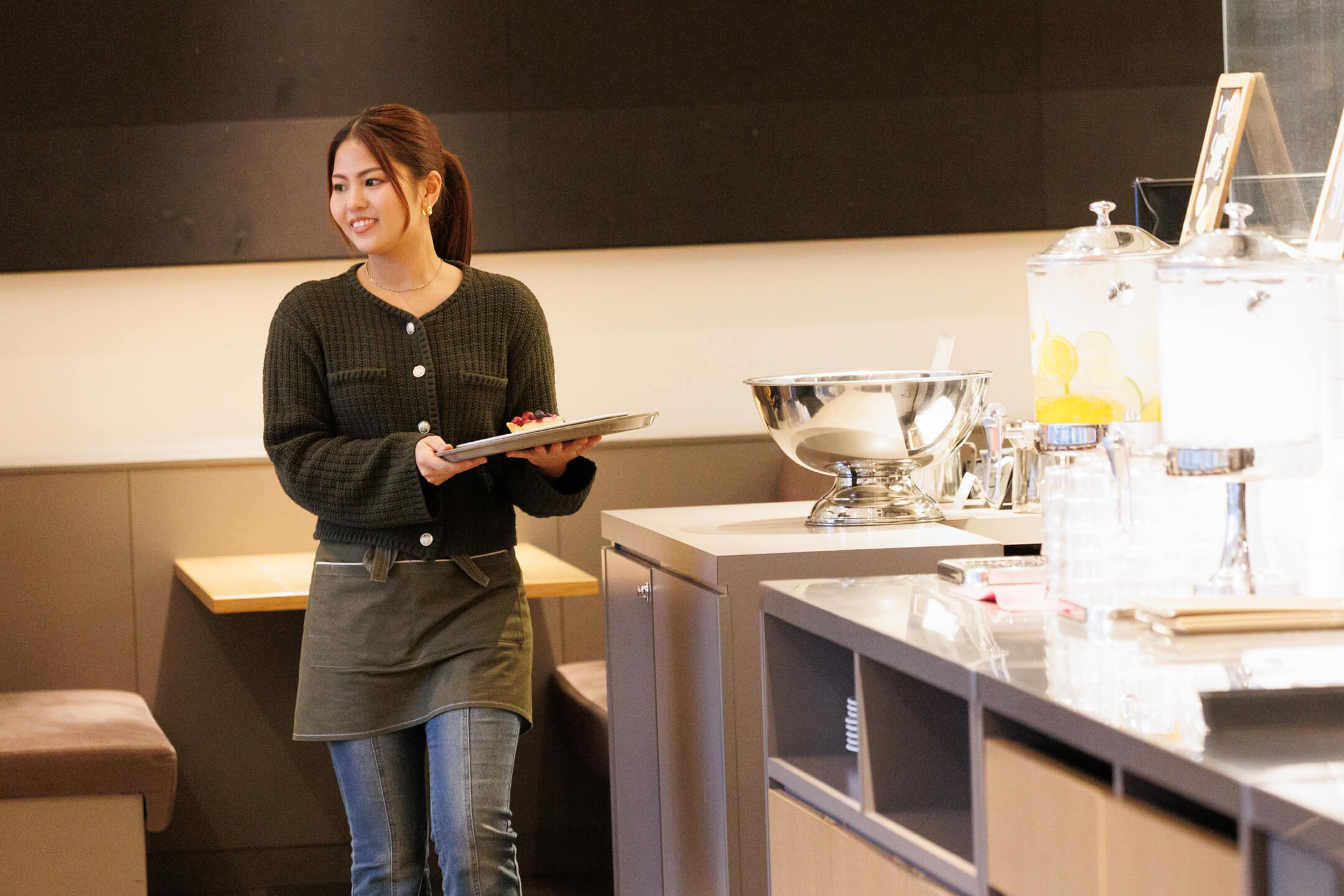 トレイに乗せたケーキを丁寧に運ぶ、接務中のひとコマ