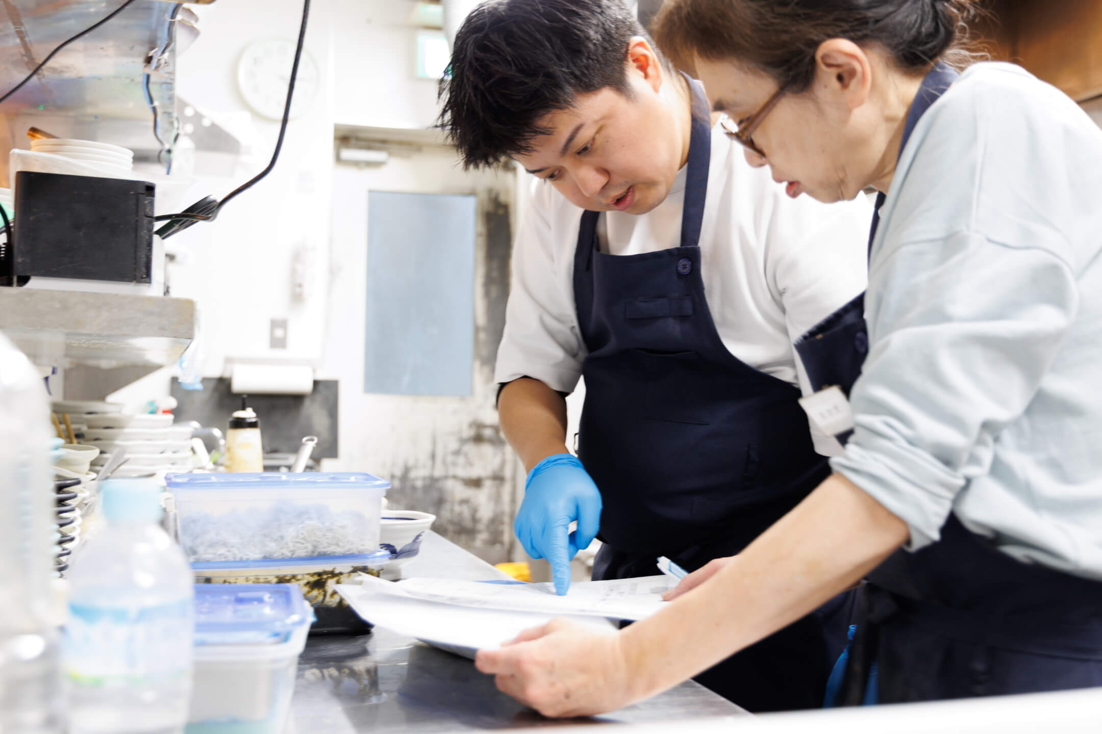 スタッフからの質問に対し、作業の手を止めて丁寧に答える様子