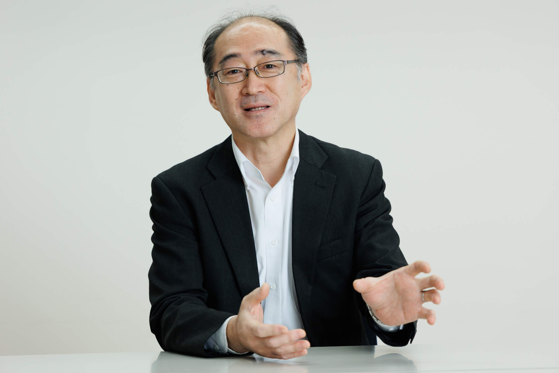 インタビューに応じ、身振り手振りを交えて和やかに談笑する様子